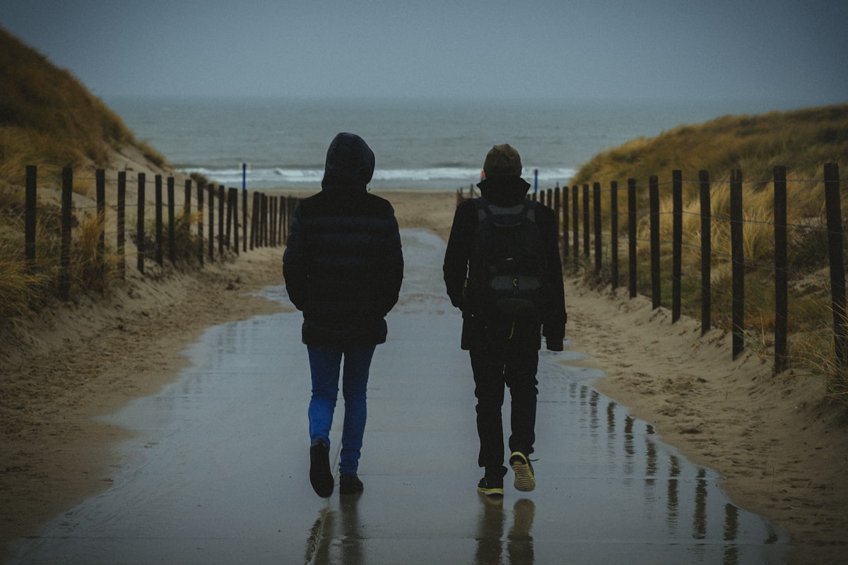 Laura et Pierre de dos, sur un chemin de dunes vers la mer